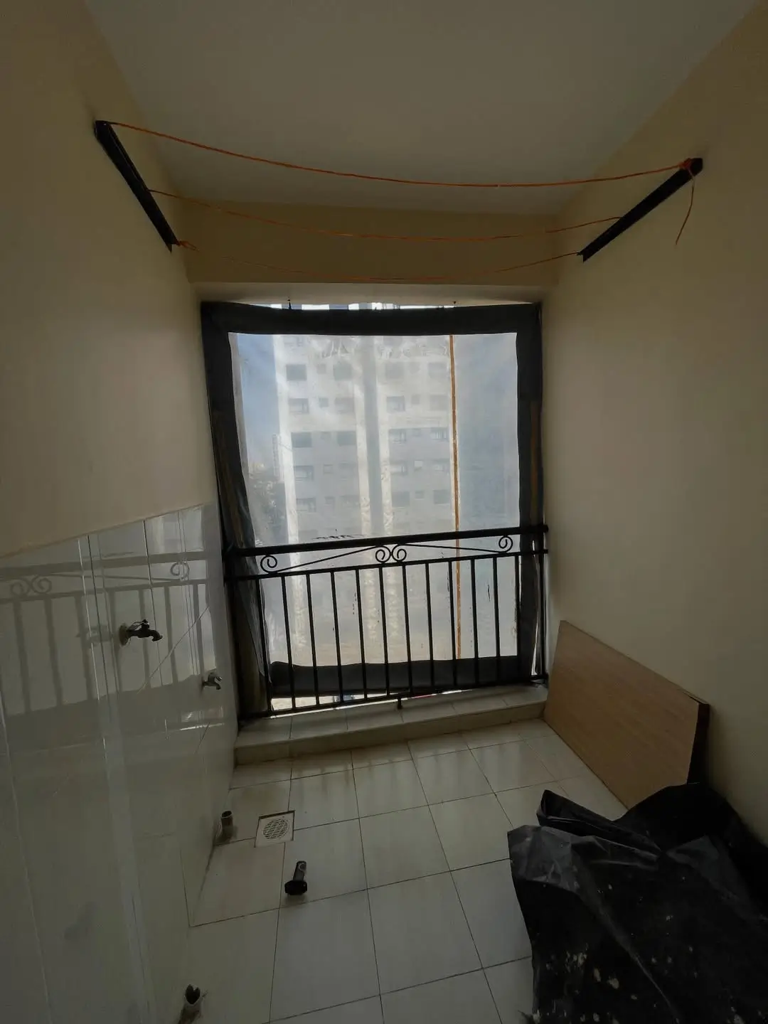 Balcony with black railing overlooking residential buildings