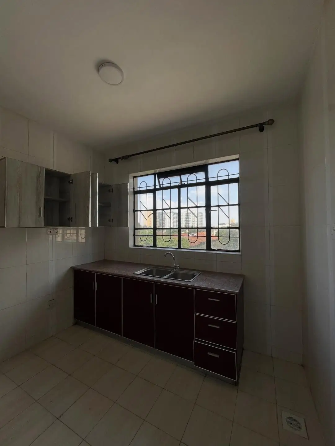 Modern kitchen with dark cabinets and sink, large window