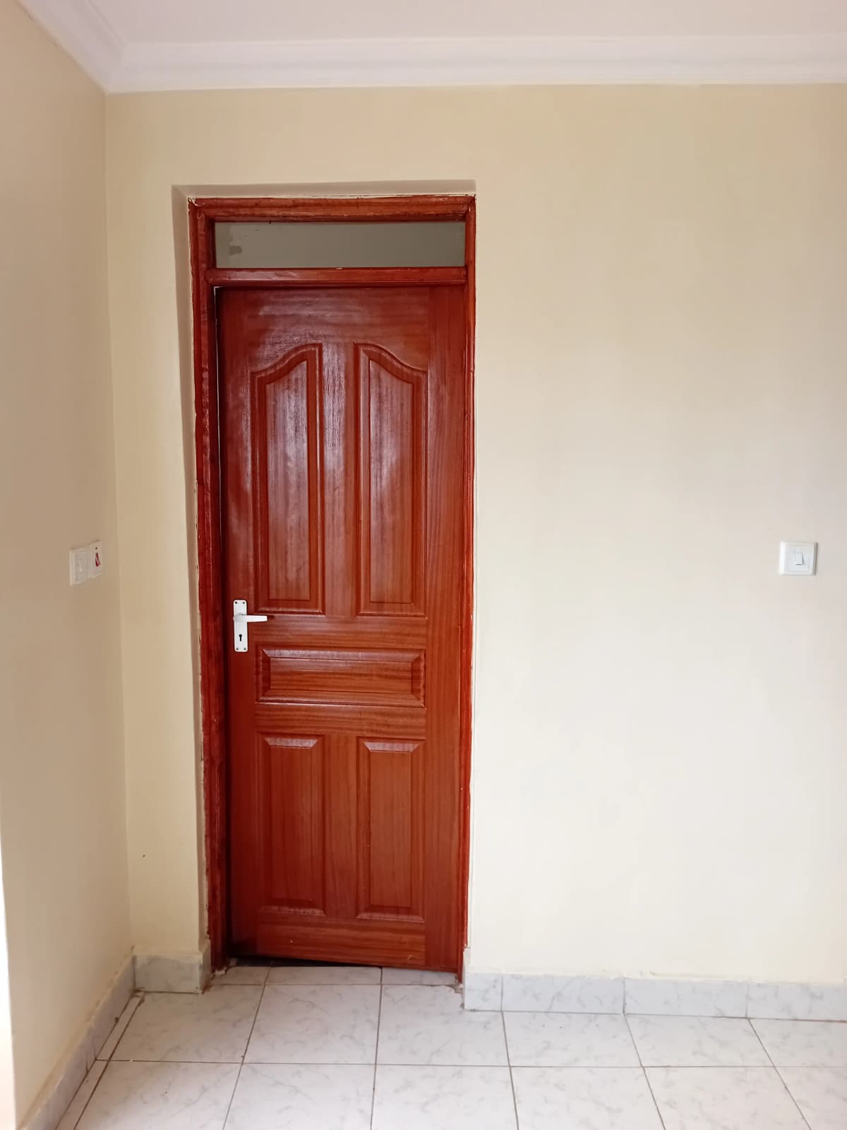 Hallway with red wooden door and cream walls