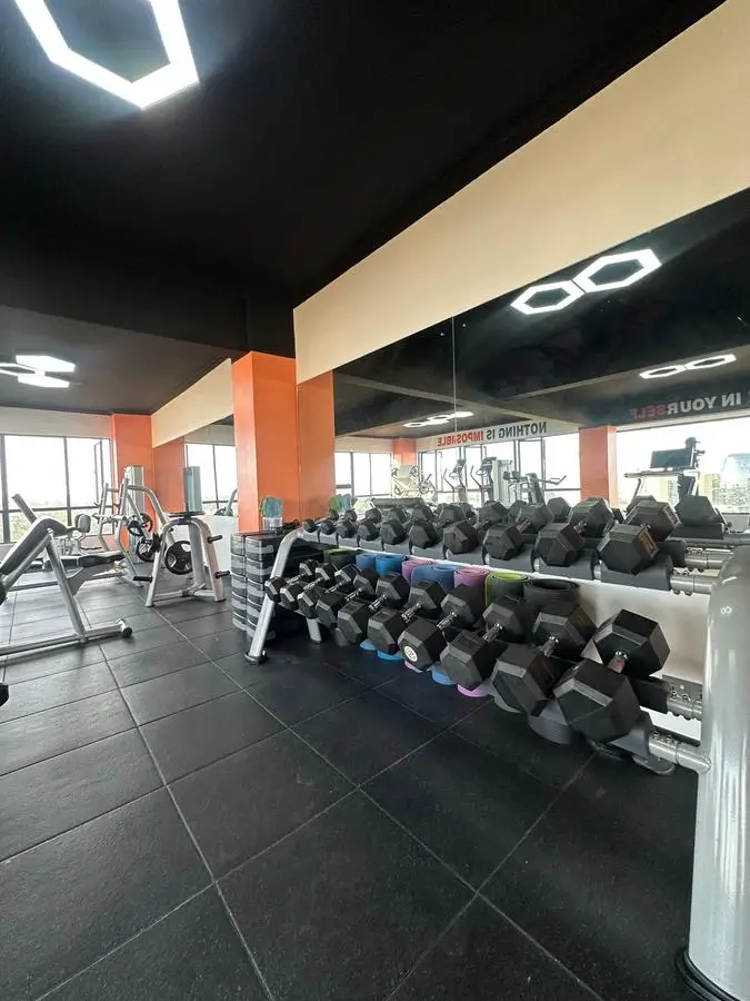 Modern gym with dumbbell racks and cardio equipment