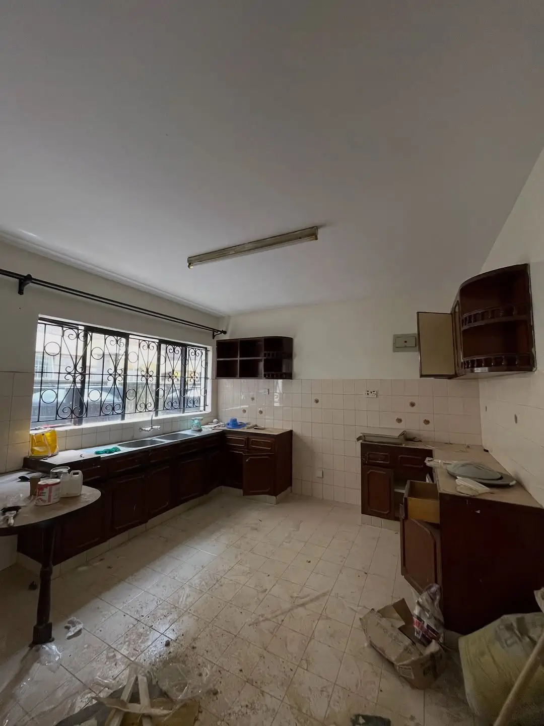 Spacious kitchen with dark wooden cabinets and tiled floor
