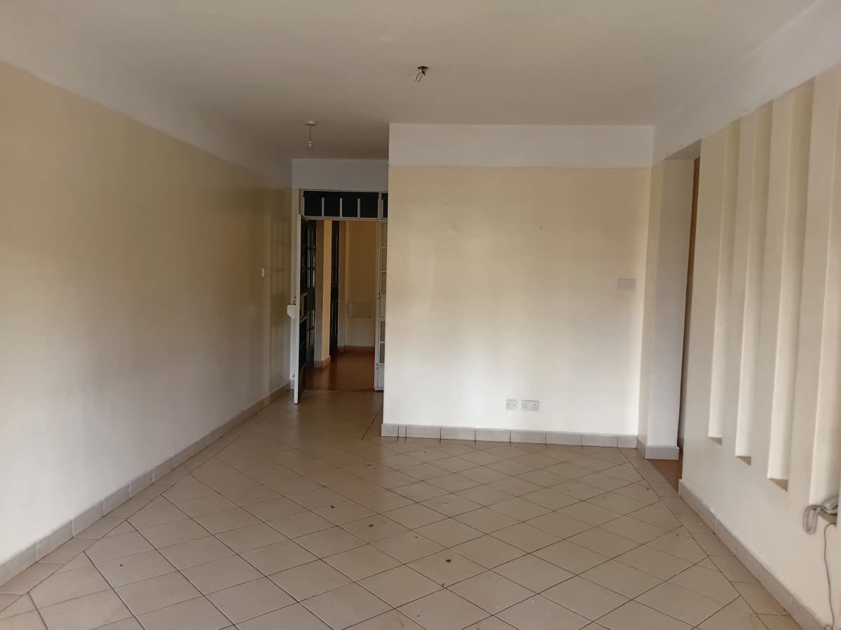 Spacious empty living room with tiled flooring and natural light