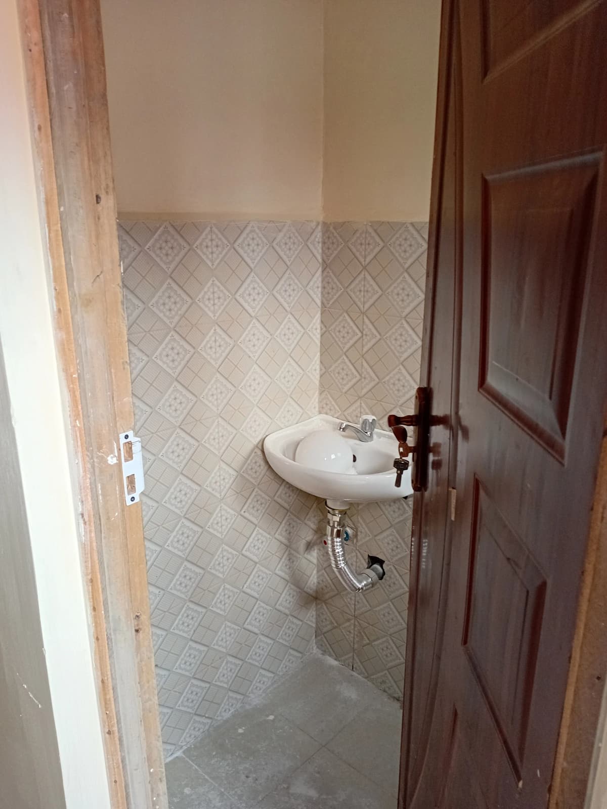 Small bathroom with pedestal sink and geometric tile walls