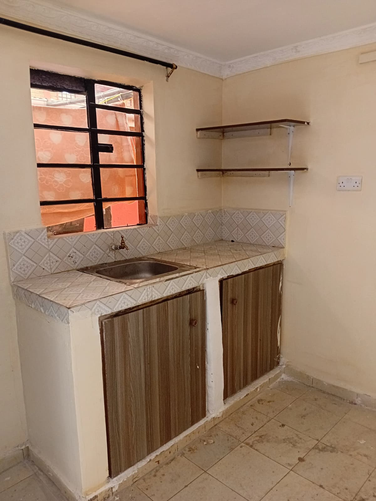 Compact kitchen with sink, wooden cabinetry, and open shelving