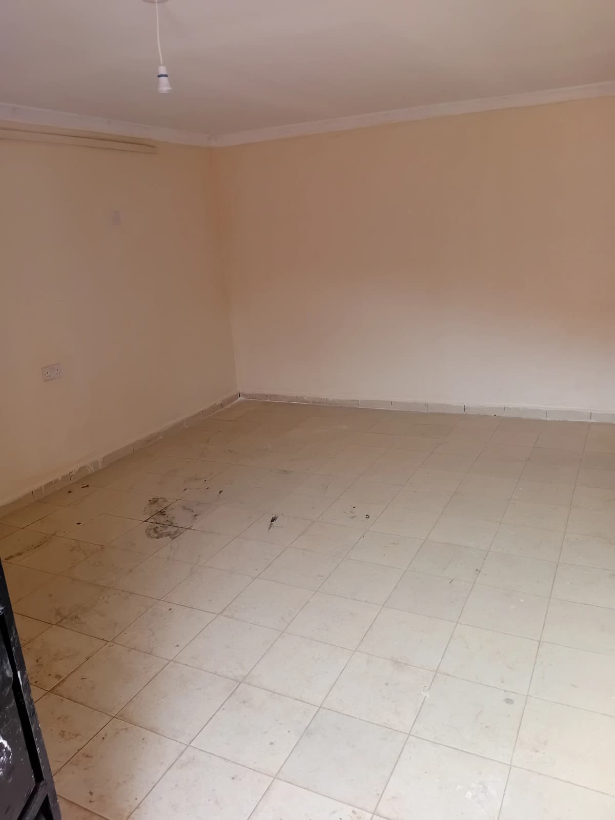 Empty living room with tiled flooring and pendant light