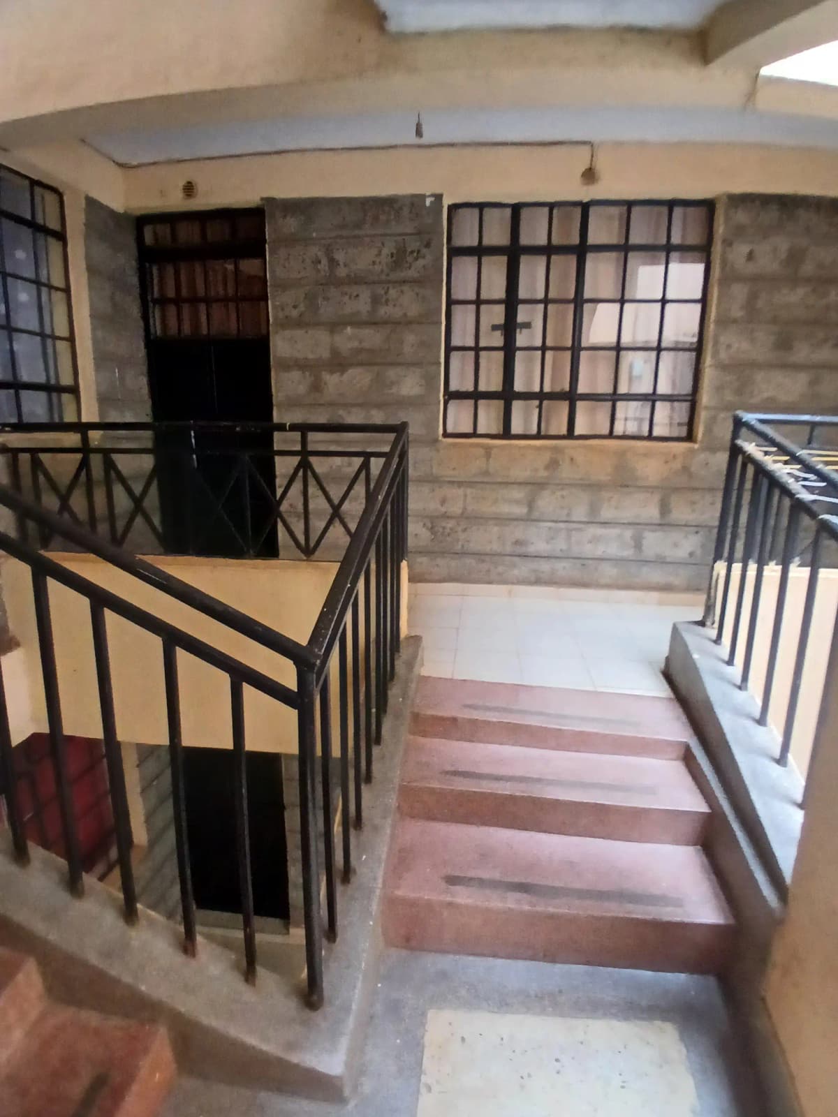Building lobby with staircase, railings, and entrance doors