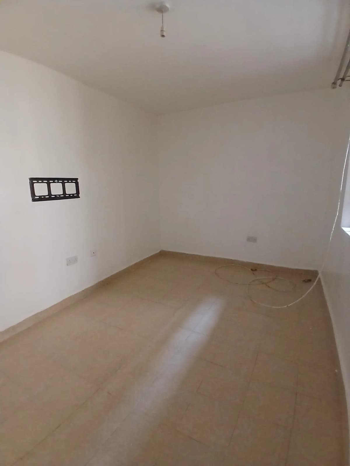 Empty bedroom with wooden flooring and switch outlets