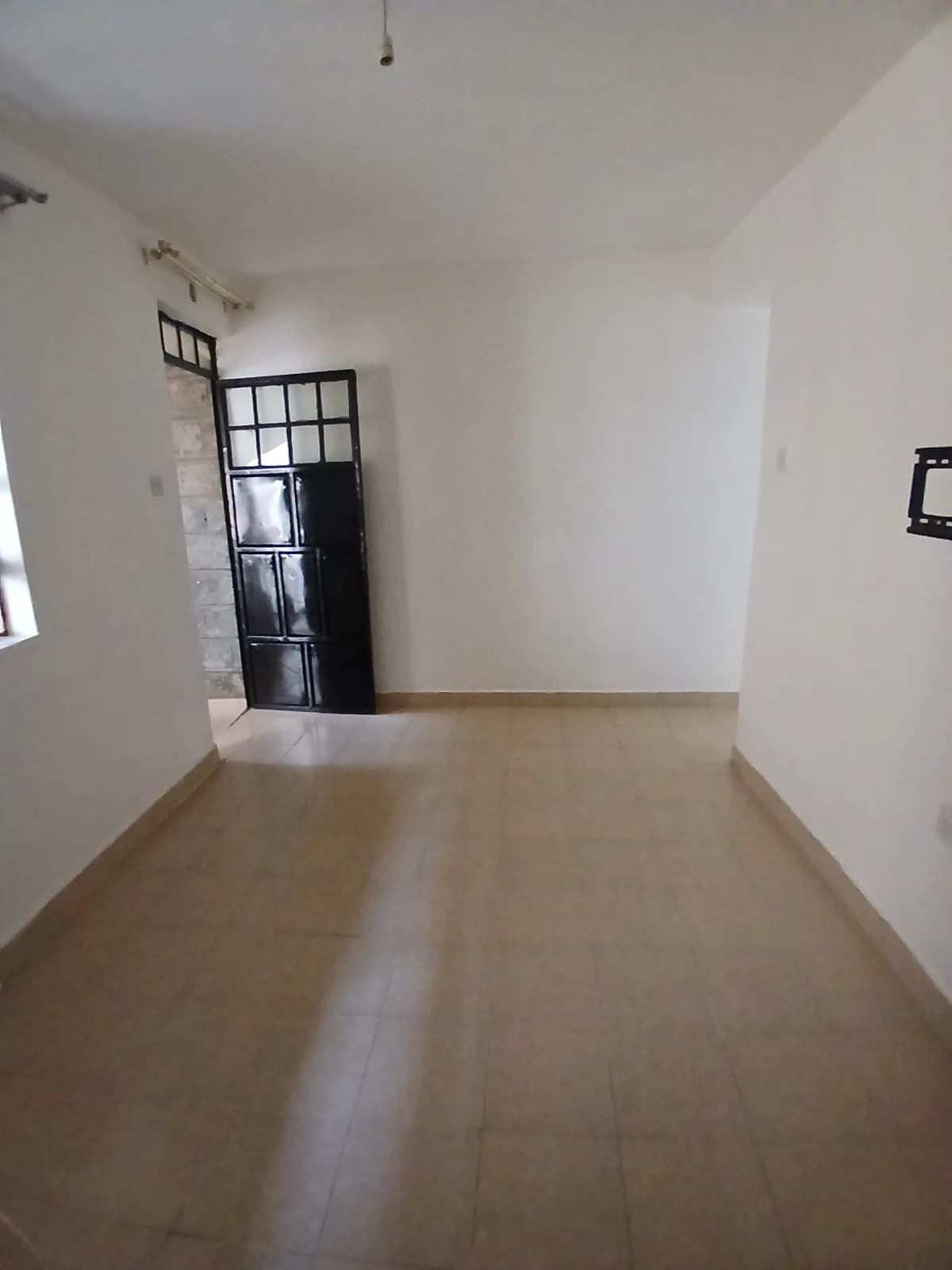 Empty living room with polished concrete flooring and glass door