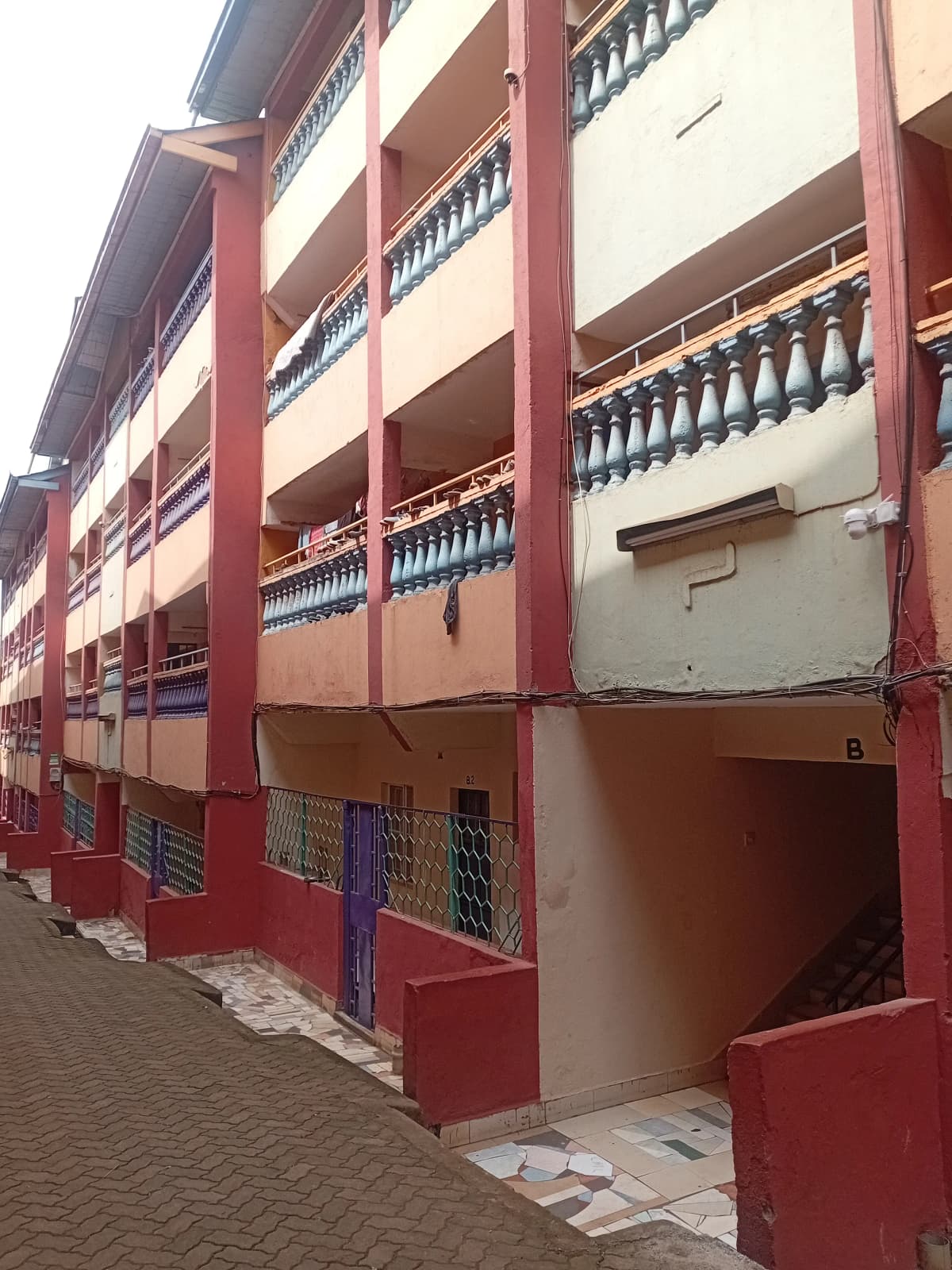 Multi-story residential building facade with red and cream coloring