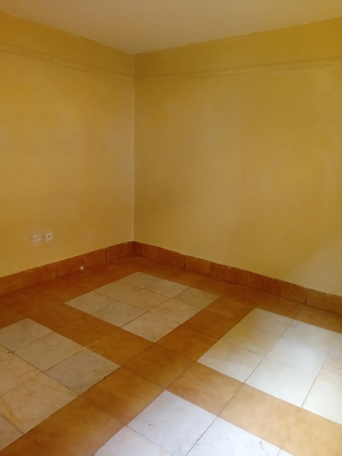 Empty room with yellow walls and partial flooring installation