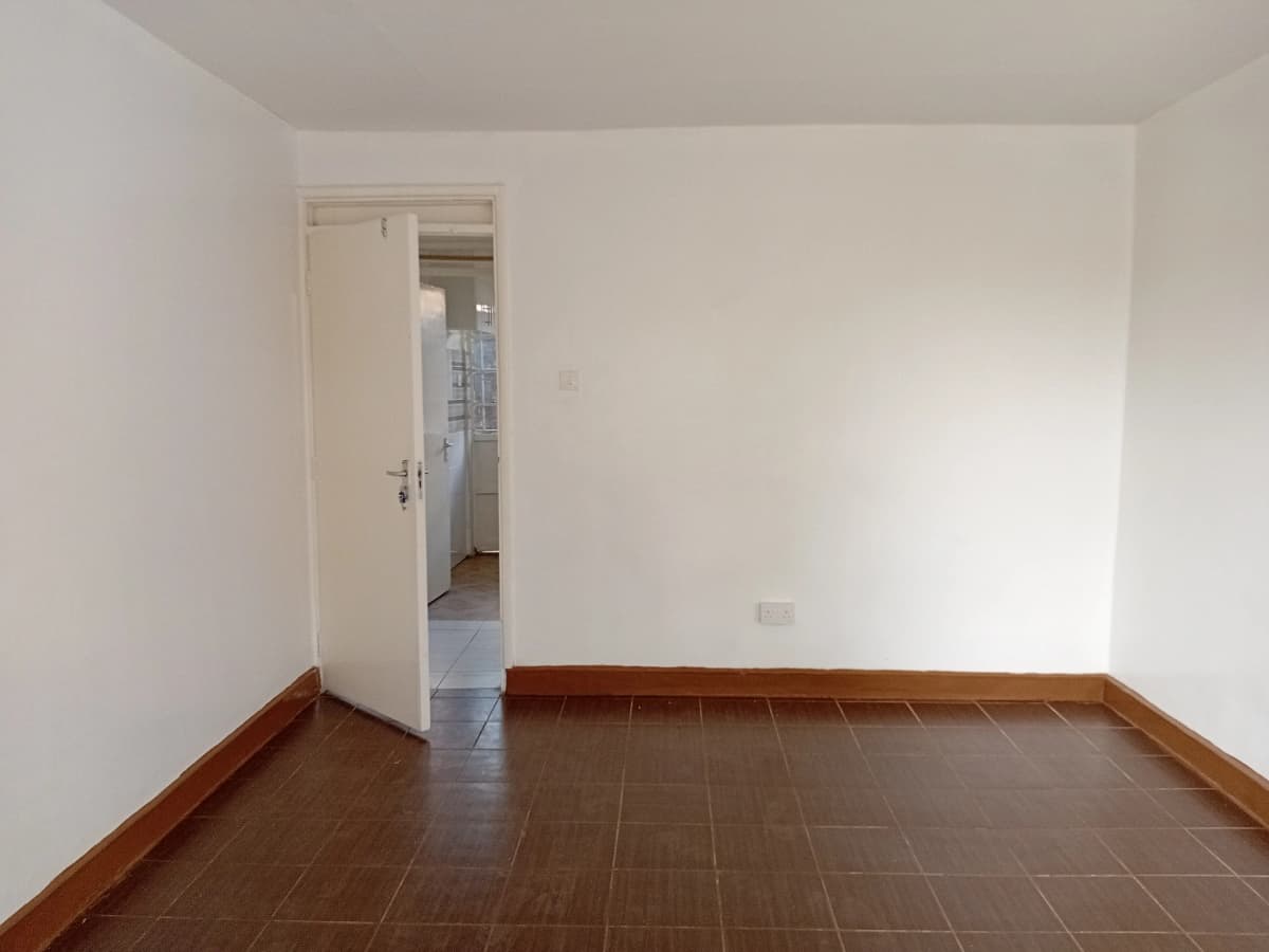 Empty bedroom with terracotta tile flooring and white walls