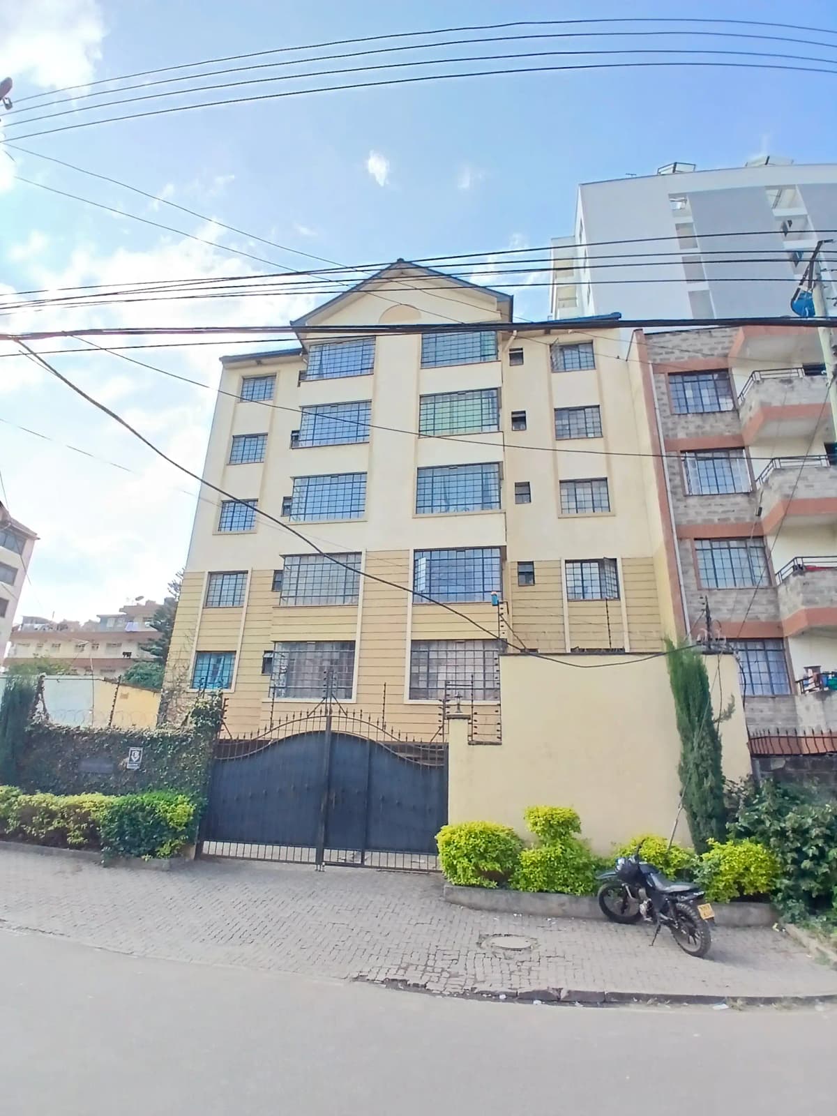 Multi-story residential building facade with gated entrance