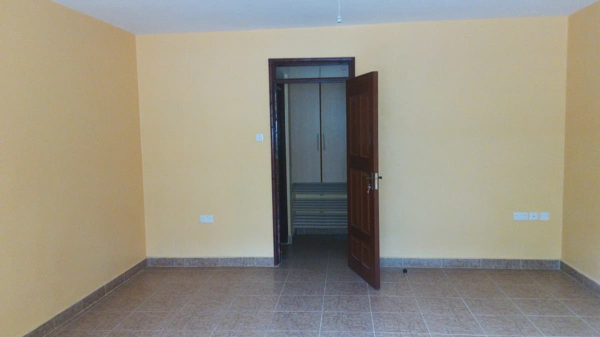 Empty living room with yellow walls and tiled flooring