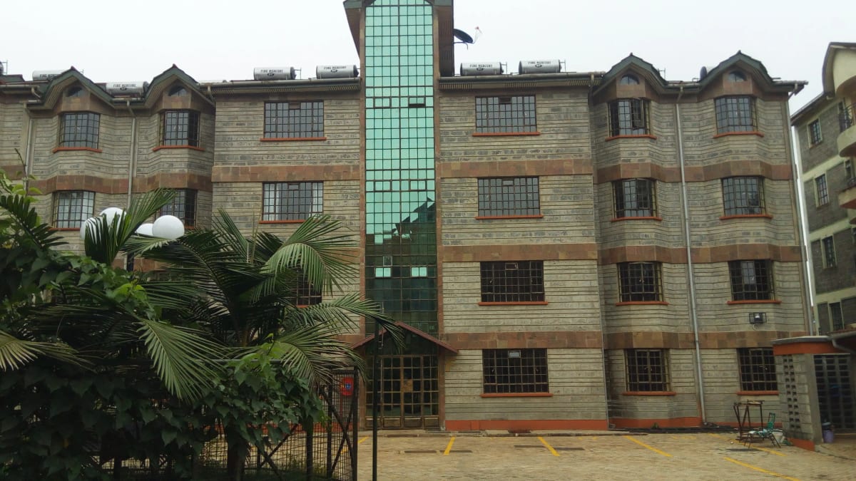 Multi-story residential building with stone facade and central tower