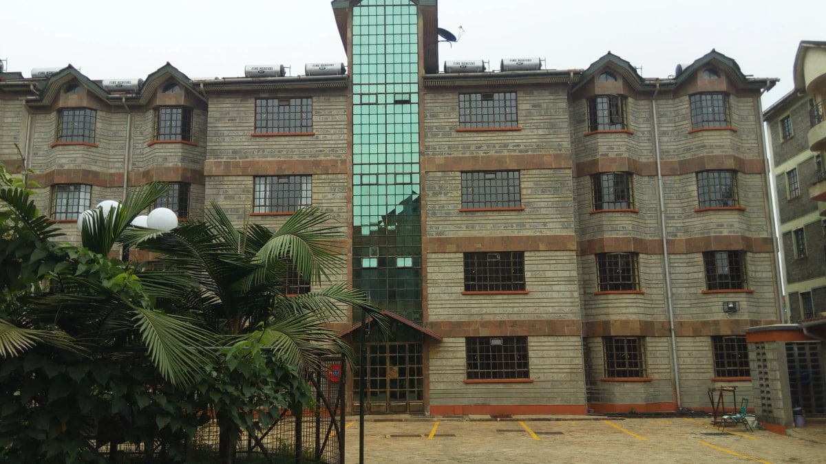 Multi-story residential building with stone facade and central tower