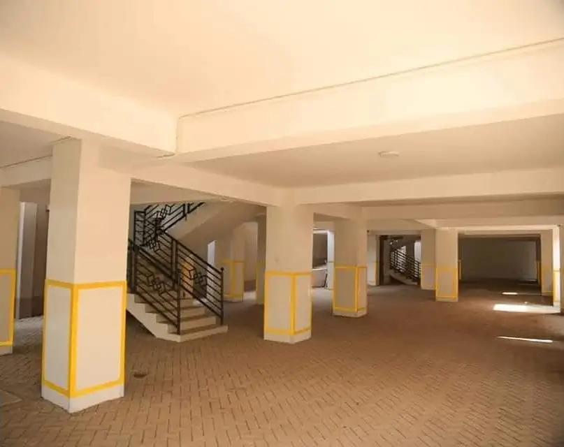 Spacious building lobby with brick flooring and staircase access