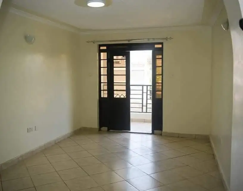 Bright empty living room with tiled flooring and balcony access