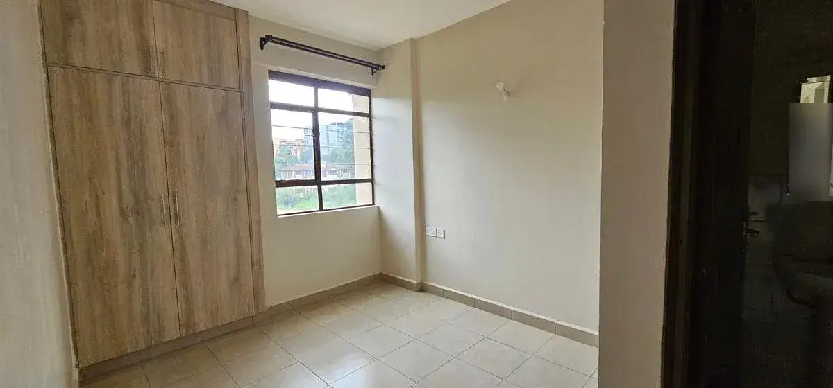 Spacious bedroom with built-in wardrobe and natural light