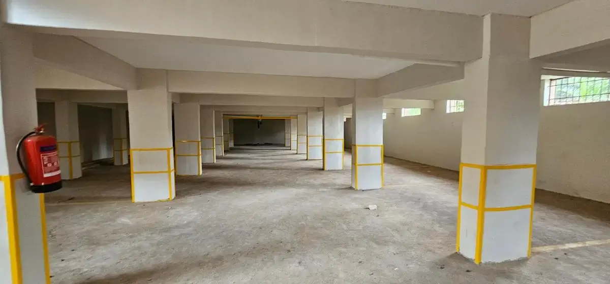 Large open lobby with concrete floors and yellow safety barriers