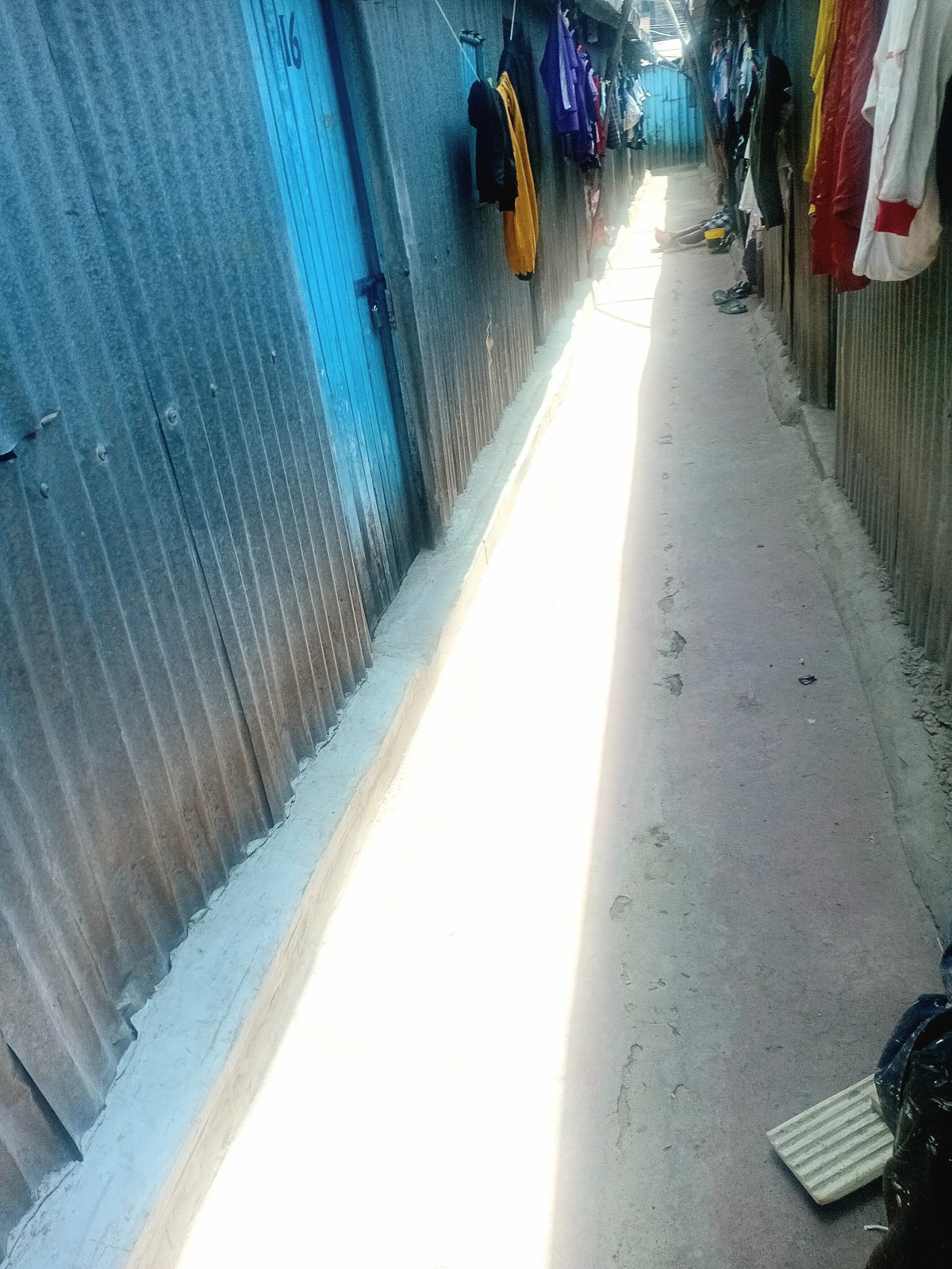 Narrow laundry drying area with clotheslines and hanging garments