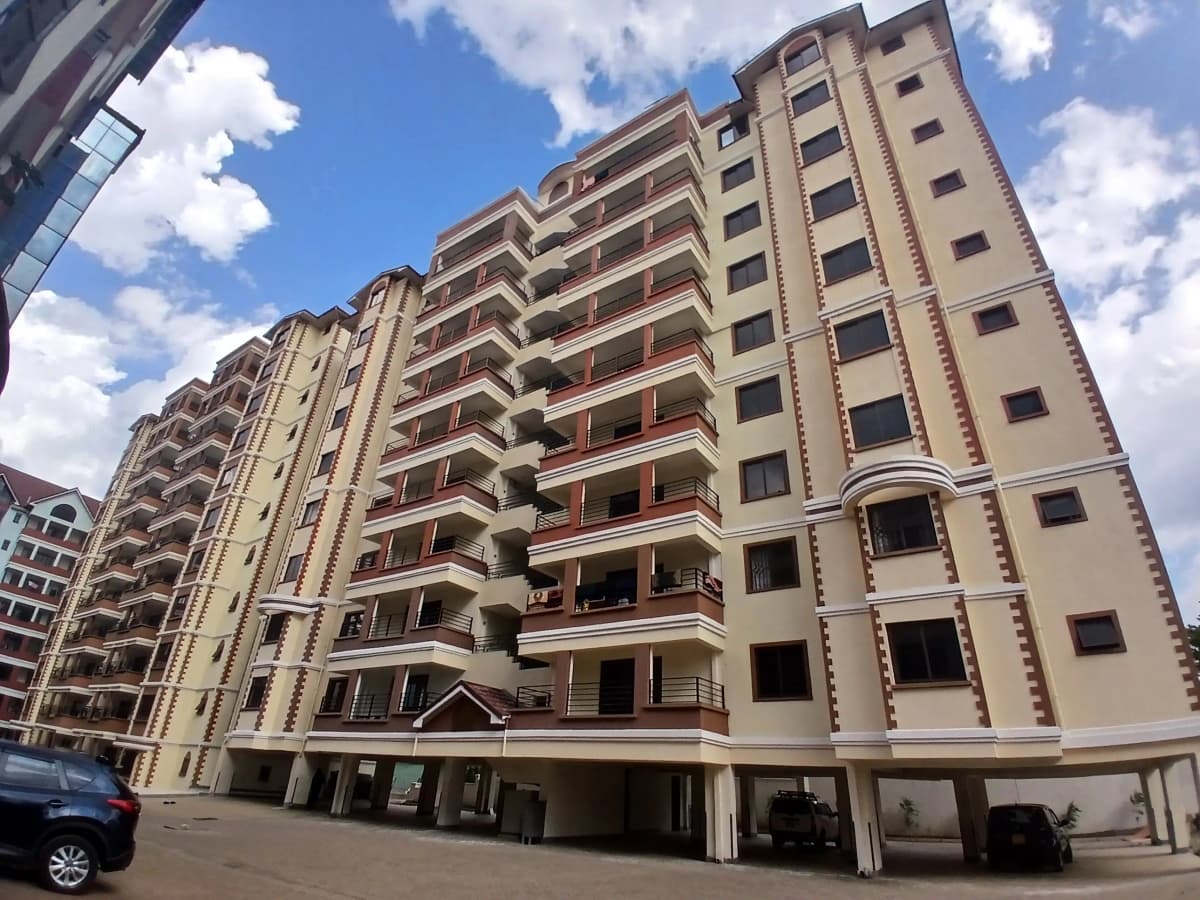 Multi-story residential building with balconies and ground-level parking