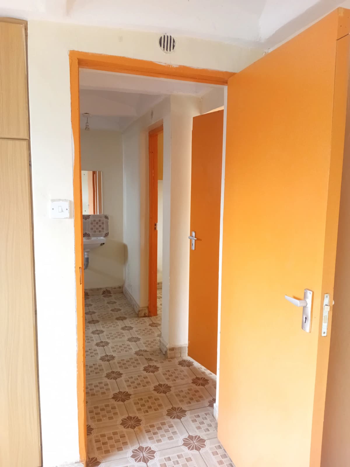 Internal corridor with orange doors and patterned flooring