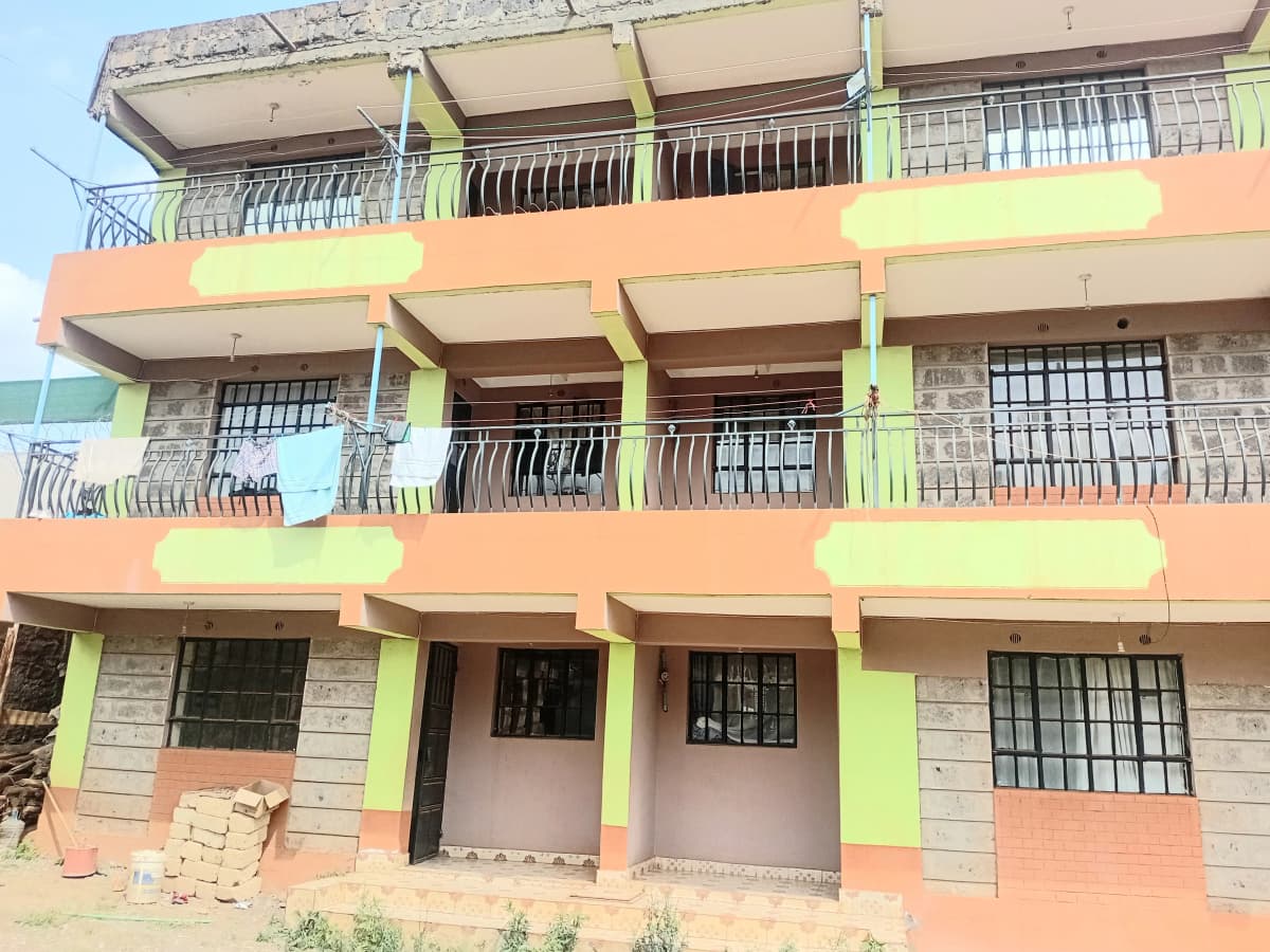 Multi-story residential building facade with balconies and green trim