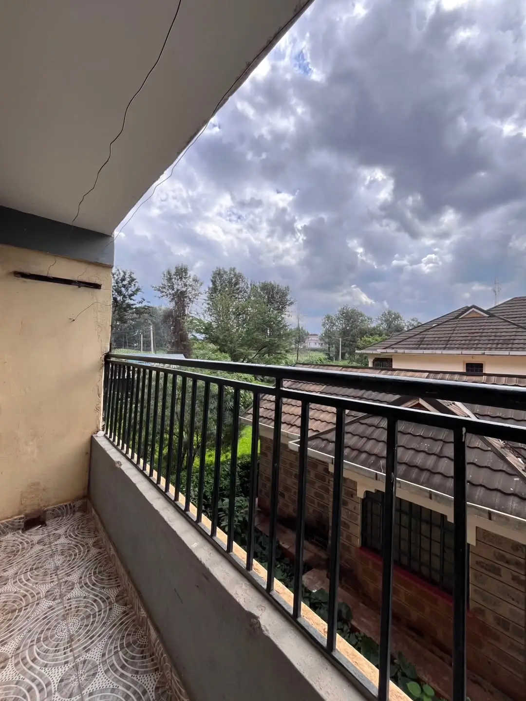 Balcony with black railing overlooking residential area