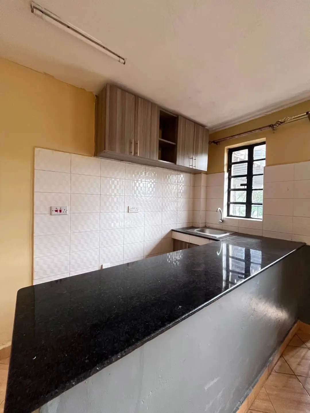 Modern kitchen with black granite countertop and white tile backsplash