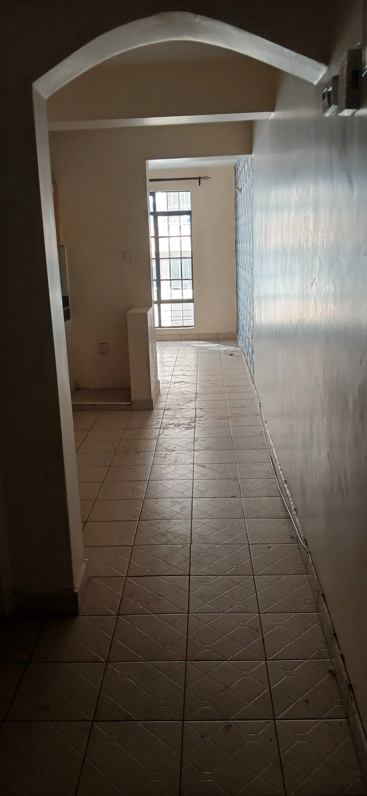 Long corridor with tiled flooring and arched doorway
