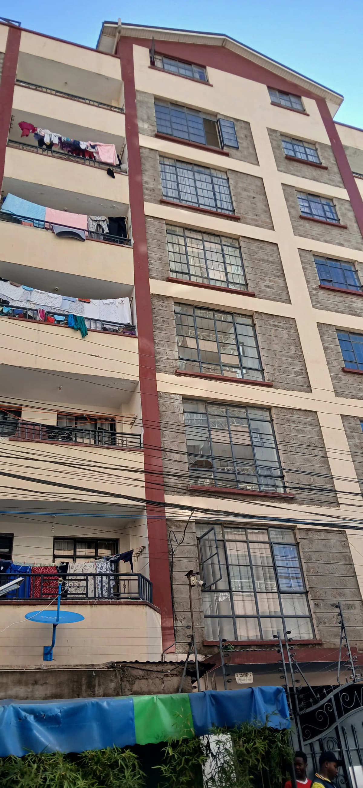 Multi-story residential building with red brick and cream facade