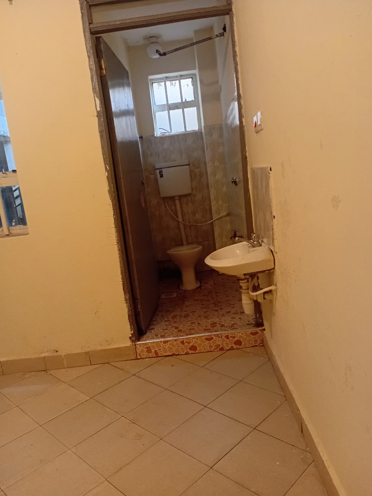 Basic bathroom with pedestal sink and toilet, tiled floor