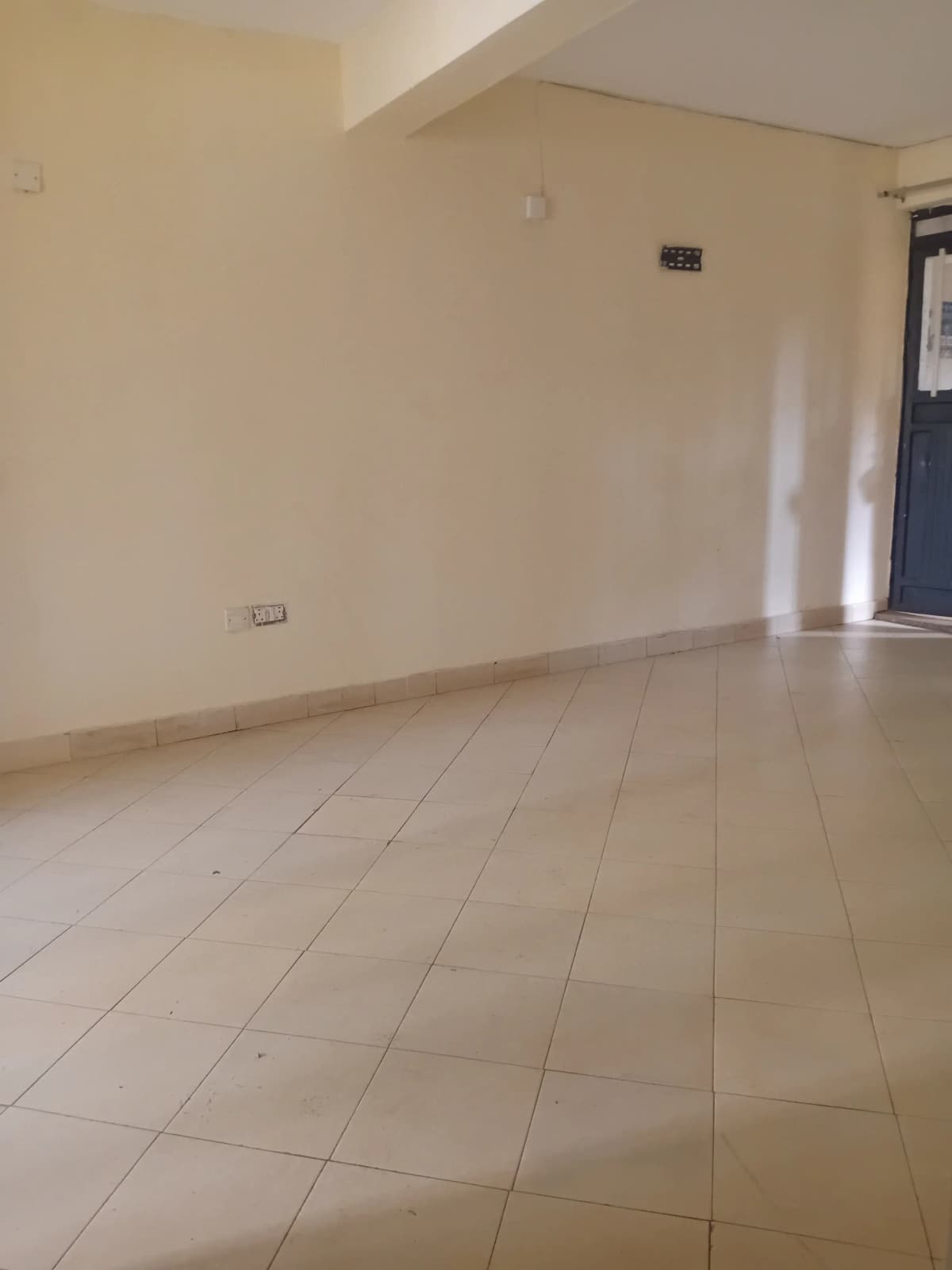 Empty living space with beige tile flooring and neutral walls