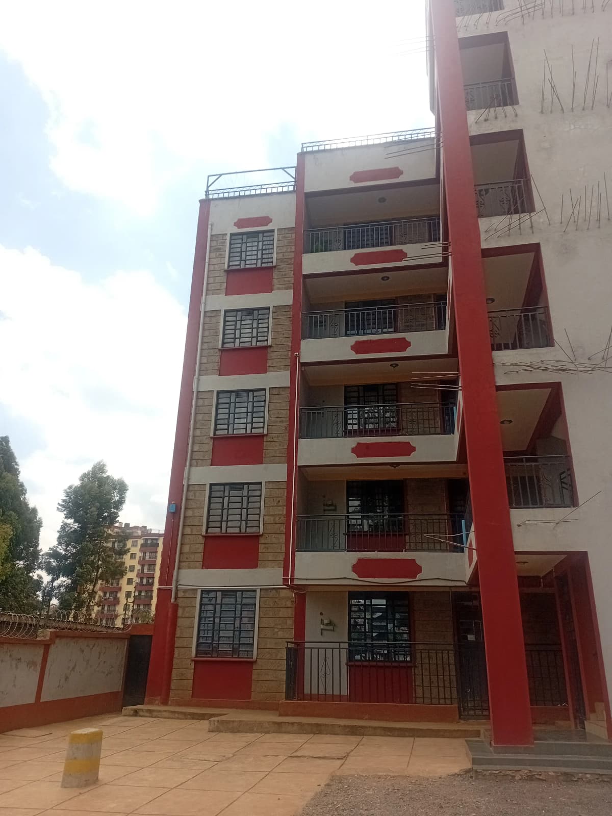 Multi-story residential building with red and cream facade