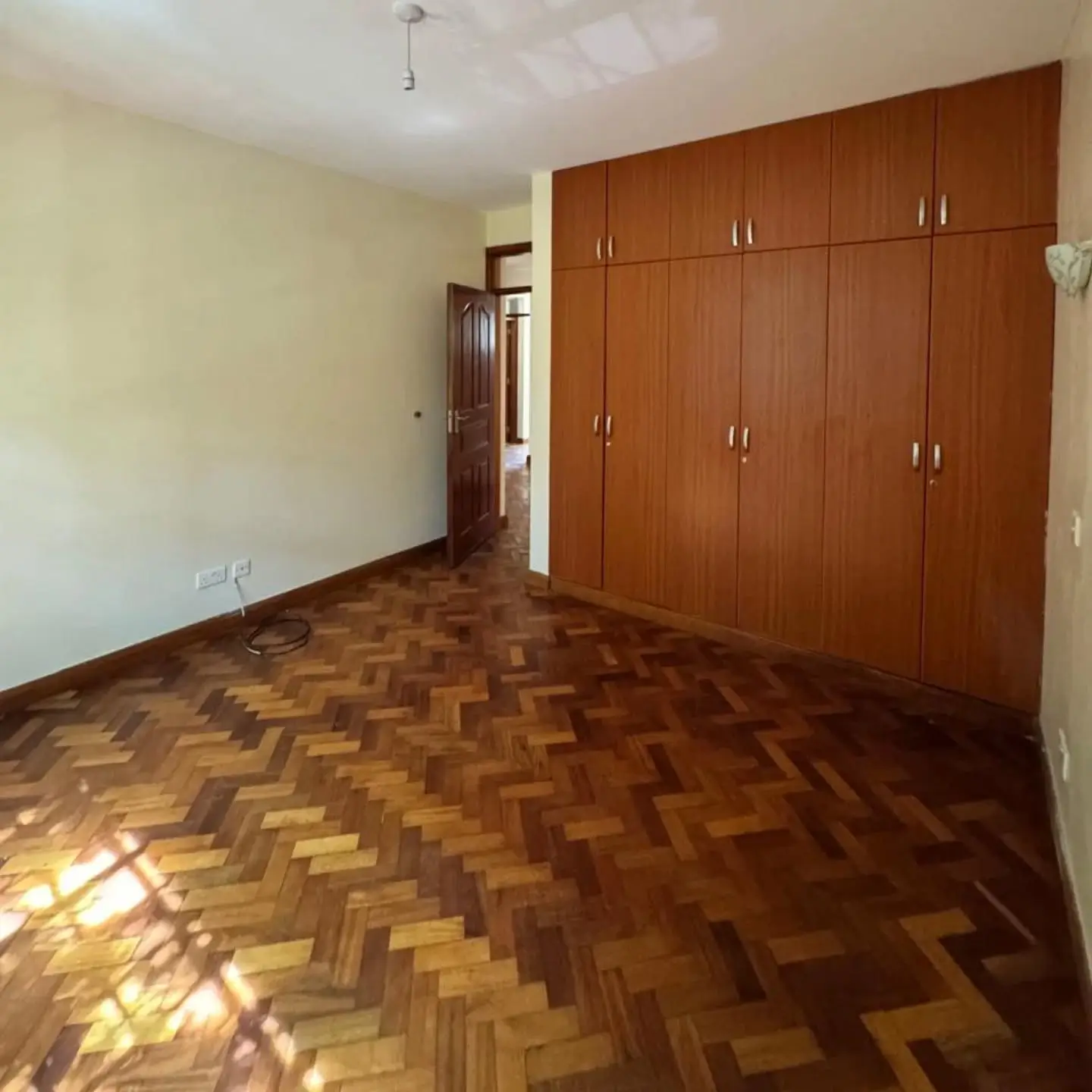 Spacious bedroom with herringbone parquet and wooden wardrobe