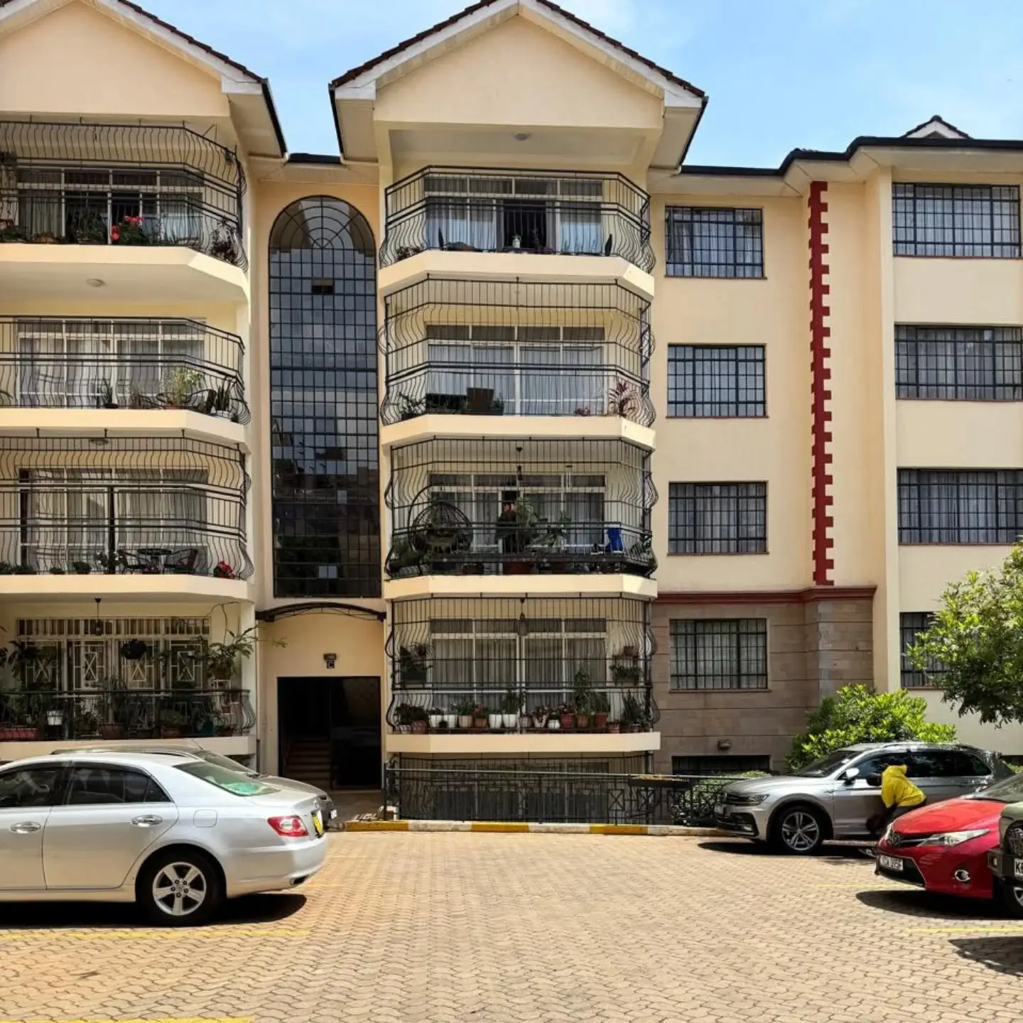 Multi-story residential building facade with parking compound