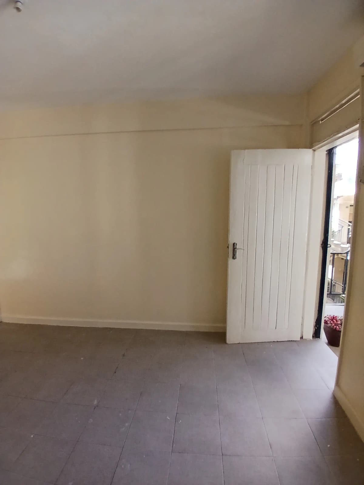 Empty bedroom with white wardrobe and balcony access