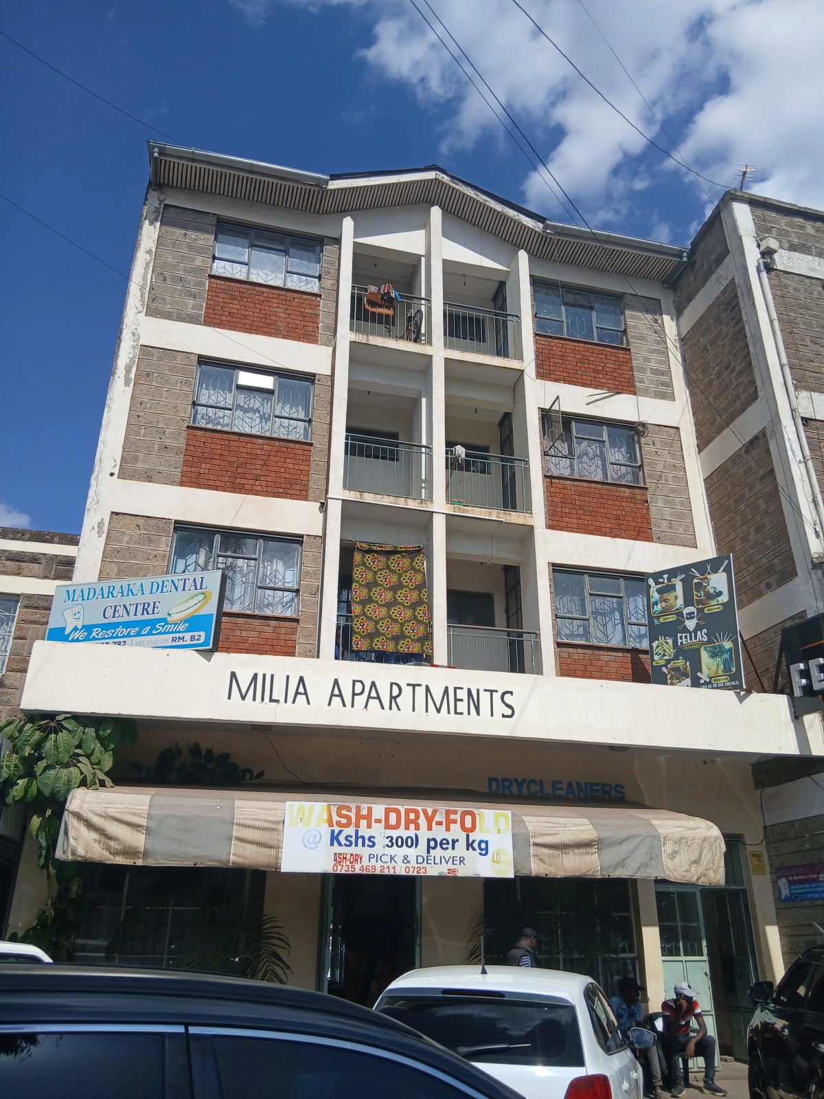 Modern multi-story apartment building facade with retail ground floor