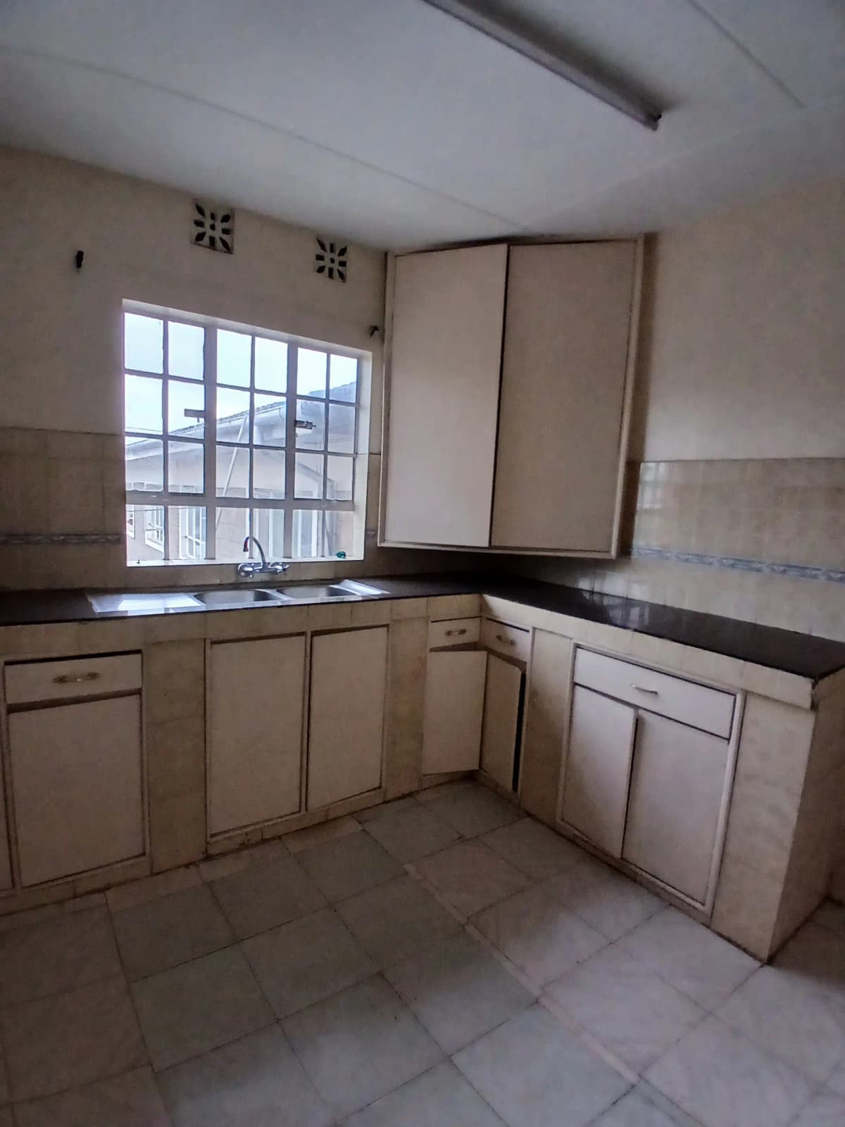 Spacious kitchen with cream cabinetry and black countertops