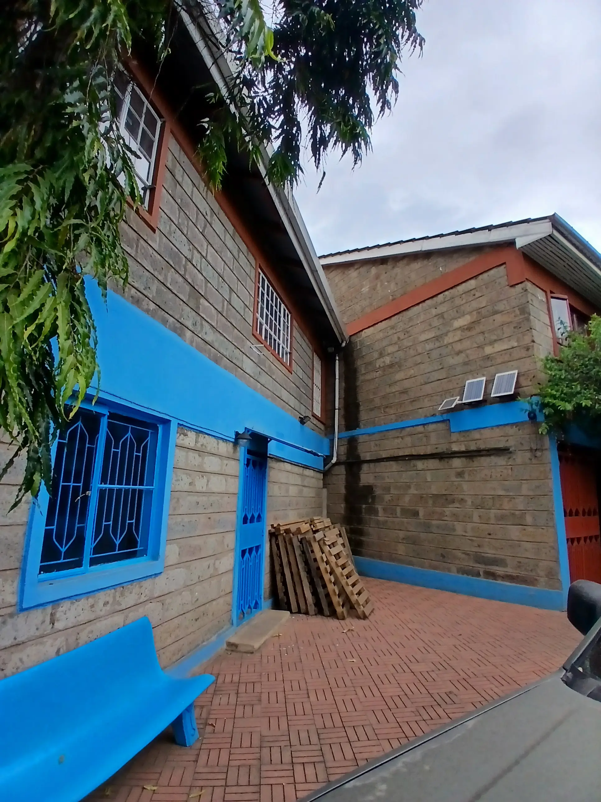Brick building exterior with bright blue painted doors and trim