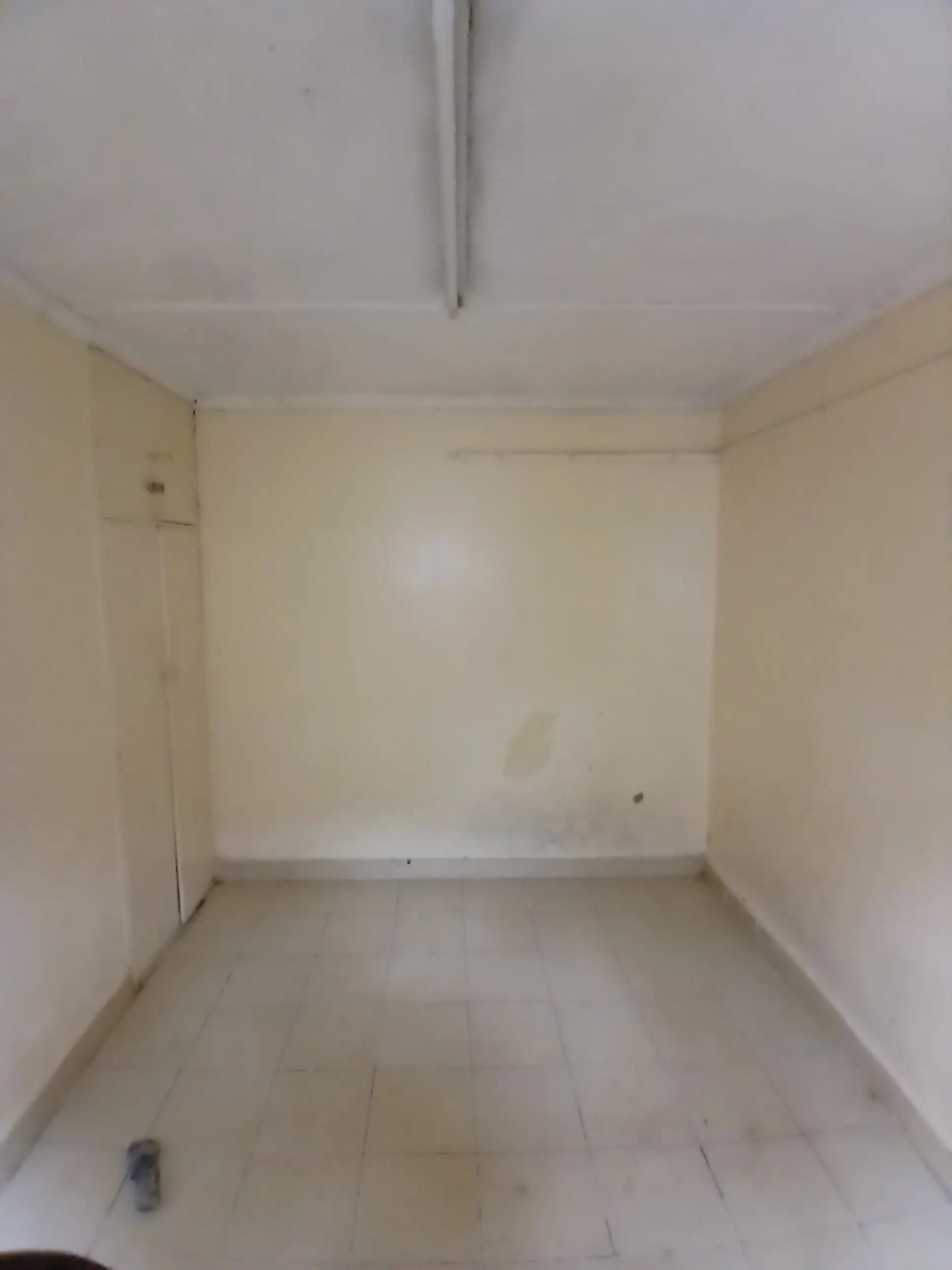 Empty bedroom with cream walls and tiled flooring