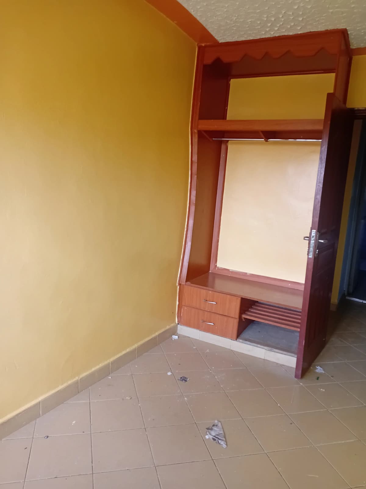 Empty bedroom with yellow walls and wooden wardrobe