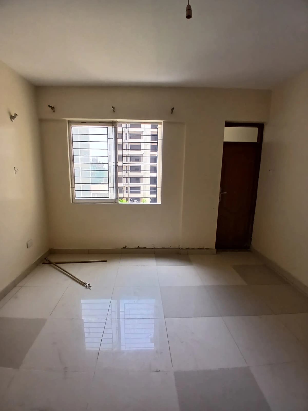 Unfurnished living room with tiled floor and barred windows