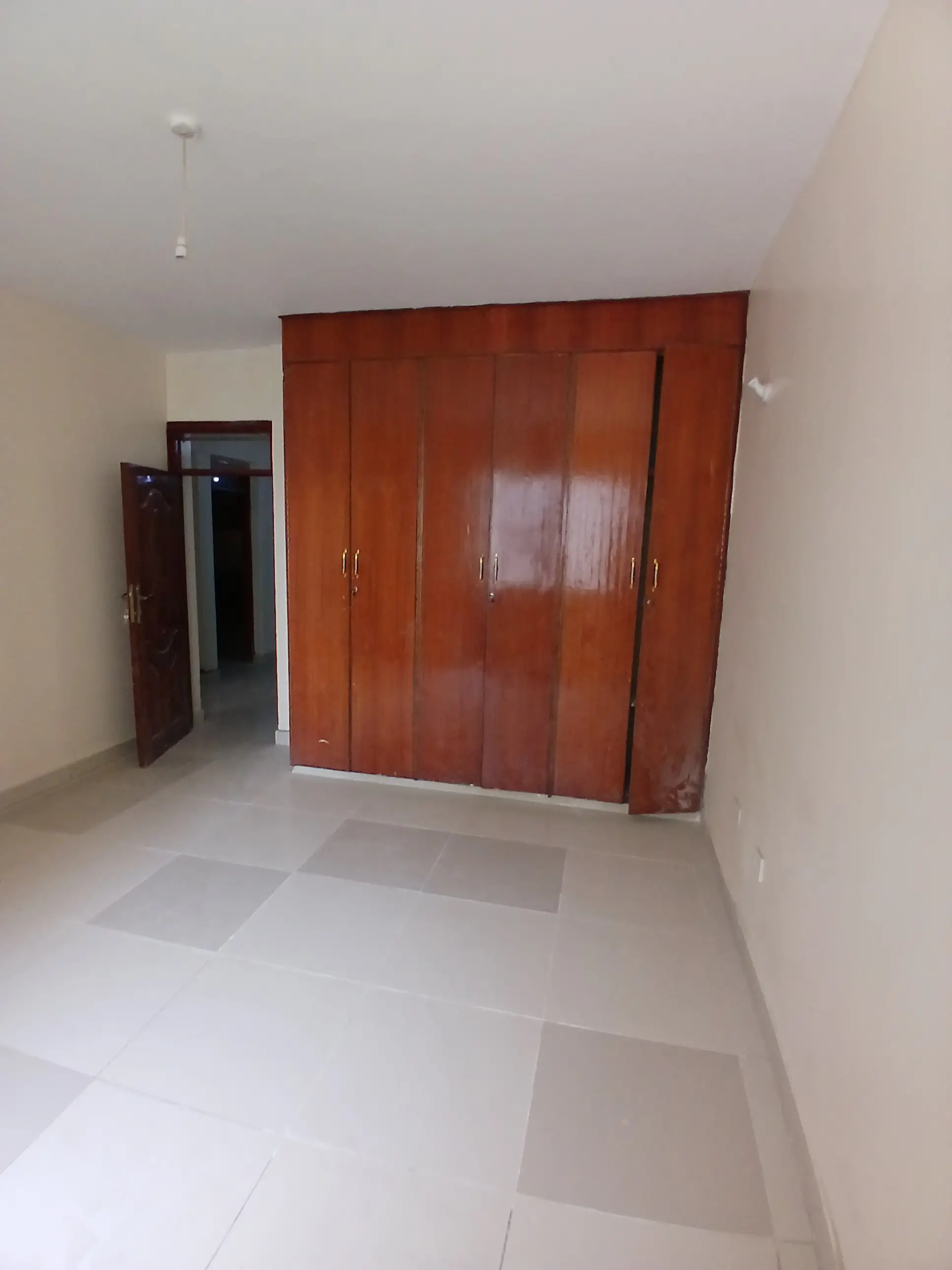 Spacious bedroom with large red wooden wardrobe