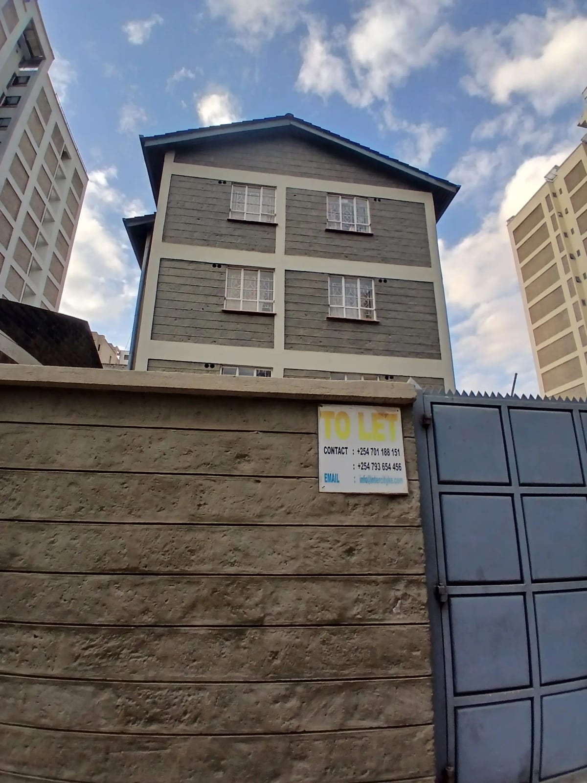 Multi-story residential building facade with compound gate