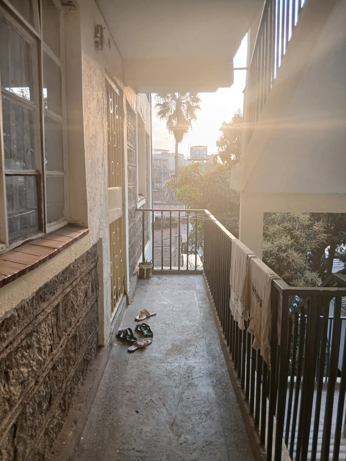 Narrow balcony with city and palm tree views at sunset