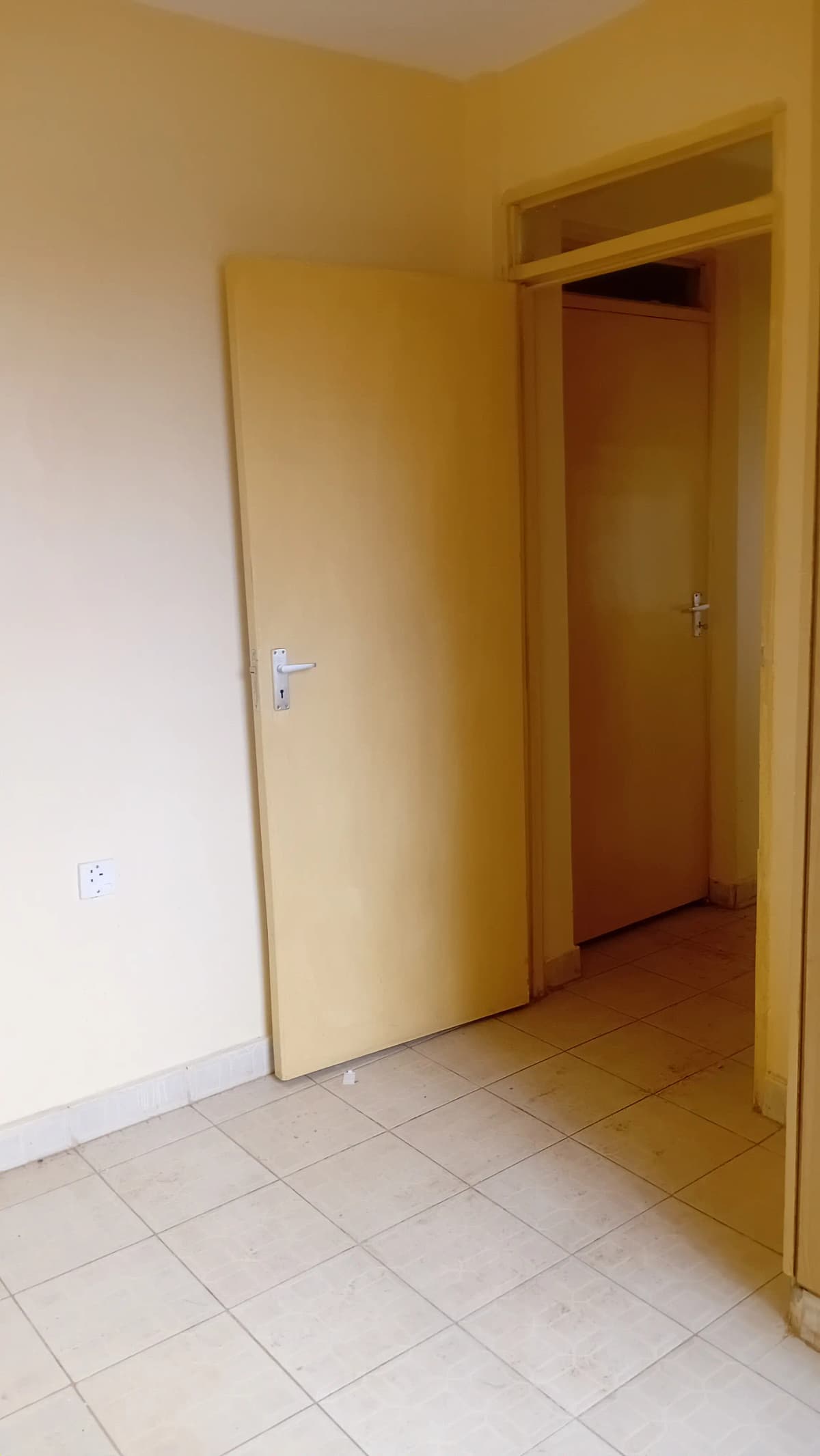 Corridor with tile flooring and cream-colored walls