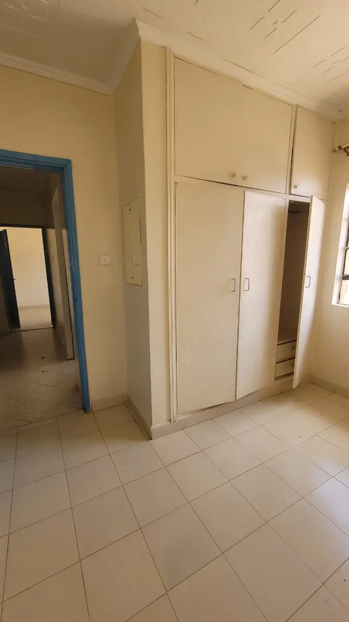 Spacious bedroom with built-in wardrobes and tiled flooring