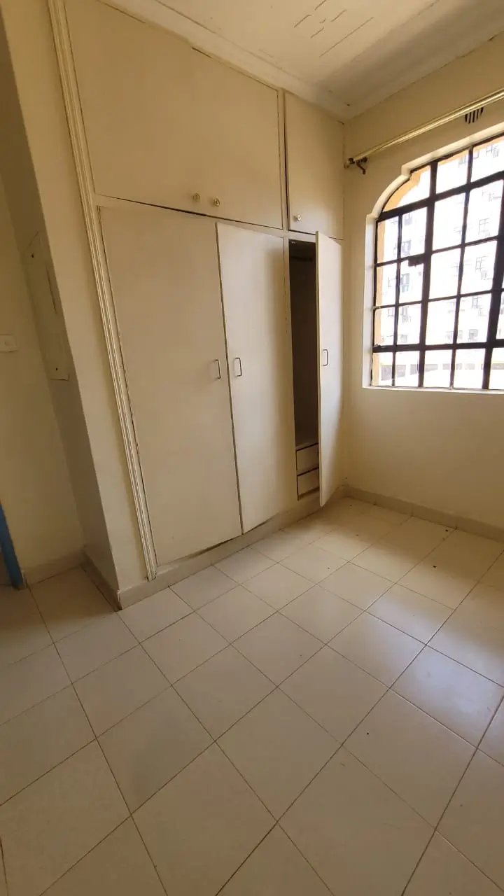 Unfurnished bedroom with built-in wardrobe and window