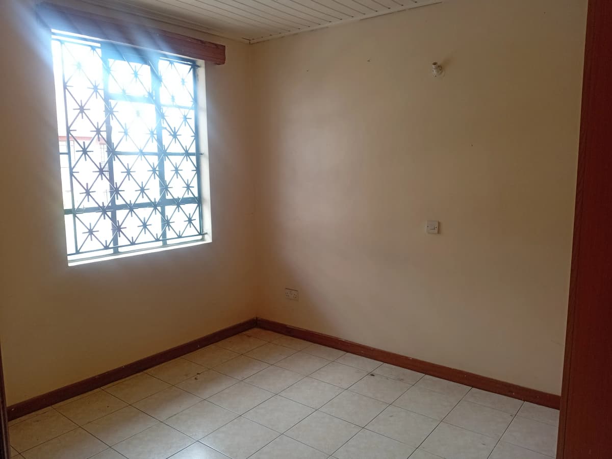 Bright bedroom with barred window and tiled flooring